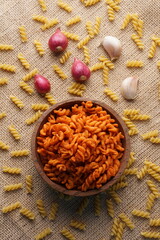 Spicy fried small macaroni crackers, on a brown cloth background, flat lay or top view, with studio lighting