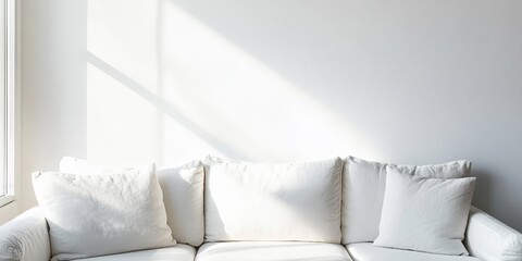 Scandinavian style corner featuring a white sofa positioned against a pristine white wall, creating a bright and airy atmosphere in the space.