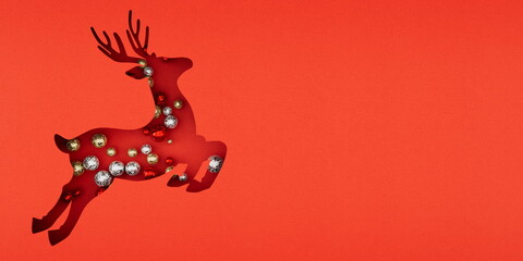 Festive Christmas reindeer cutout filled with colorful ornaments on a vibrant red backdrop, capturing the essence of holiday cheer and creative decoration