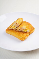 mayonnaise rissoles enclosed in crepe-like wrappers and rolled into bread crumbs and fried. served on wood plate. perfect for recipe, article, catalogue, promotion, or any cooking contents.