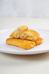 mayonnaise rissoles enclosed in crepe-like wrappers and rolled into bread crumbs and fried. served on wood plate. perfect for recipe, article, catalogue, promotion, or any cooking contents.