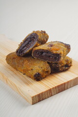 vegetables risoles enclosed in crepe-like wrappers and rolled into bread crumbs and fried. served on wood plate. perfect for recipe, article, catalogue, promotion, or any cooking contents.