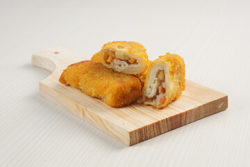 vegetables risoles enclosed in crepe-like wrappers and rolled into bread crumbs and fried. served on wood plate. perfect for recipe, article, catalogue, promotion, or any cooking contents.