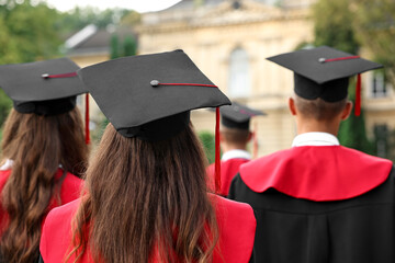 Students at graduation ceremony outdoors, back view