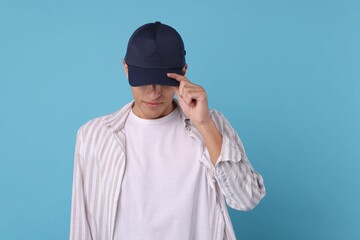 Man in stylish baseball cap on light blue background. Mockup for design