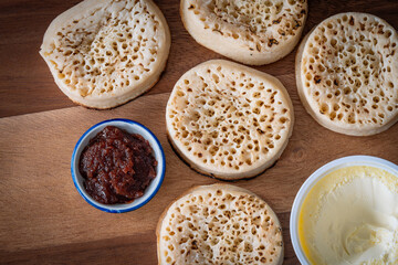 British crumpets, jam and clotted cream on wooden background