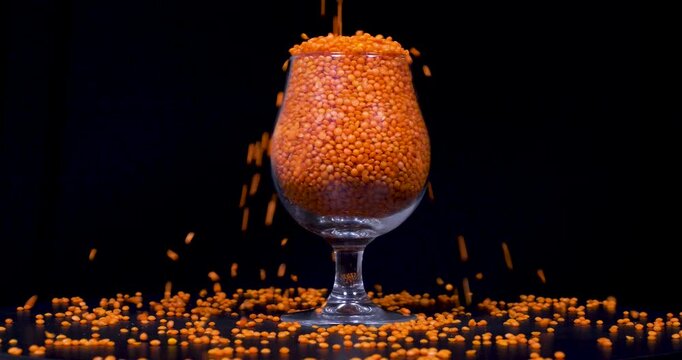 Close-up footage of red lentil on black background.