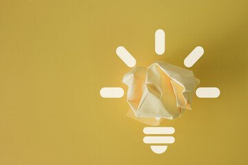 ellow crumbled paper with light bulb icon symbolizing creativity, brainstorming,inspiration,...