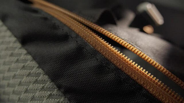Close-up of a Backpack Zipper with Orange Pull Tab in Use