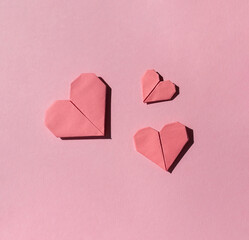 Pink paper origami hearts on the pink background. Valentine's day celebration concept