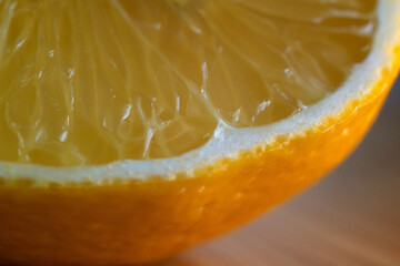 Macrophotography of the pulp and peel of a yellow lemon, cut in half. The texture of the peel and...