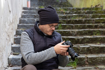 A man with a camera walking through an autumn city.