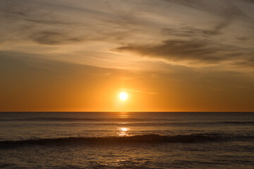 The sun reflecting on the sea in the golden hour in the atlantic ocean in Cadiz, Spain. Reflection of golden sunlight on the water. Sunset view of the sea with bright sunlight.