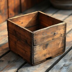 An empty rustic wooden crate sits on a wooden surface. The crate is square and made of aged wood showing its grain and wear.