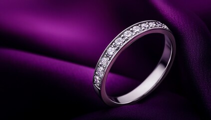 Elegant diamond ring on a rich purple fabric background.