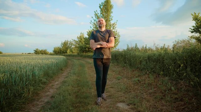 Bald man energetically dancing, mimicking iconic dancer moves. Guy passionately performing expressive choreography, channeling famous style. Male artistically replicating signature dance gestures with