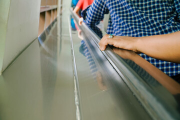 closeup of hand holding escalator handle with copy space