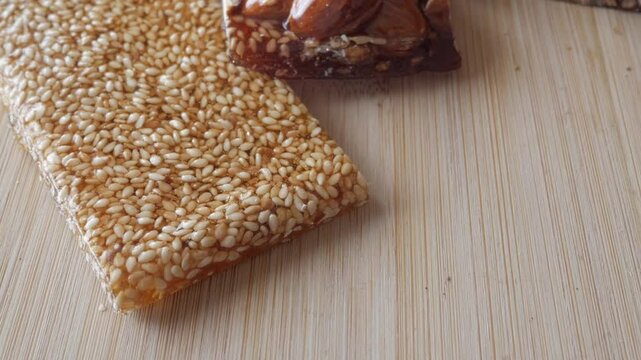 Zoom out view of almonds and sesame bars with honey. Traditional spanish Christmas sweet, Guirlaches.