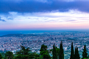 view of Barcelona from a hilltop, capturing the sprawling cityscape against a dramatic sky,...
