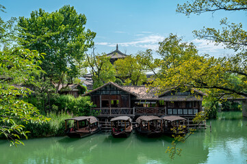 Fototapeta premium Buildings and boats on a river in a village in southern China