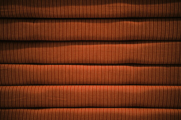 Decorative red striped cushions in the store for a sofa or chair are stacked. Close-up view. Minimalistic background with copy space. Home furniture and Accessories Store.