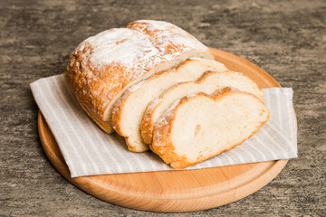 Assortment of freshly sliced baked bread with napkin on rustic table top view. Healthy unleavened bread. French bread slice