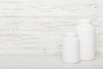 supplement pills with medicine bottle health care and medical top view. Vitamin tablets. Top view mockup bottle for pills and vitamins with green leaves, natural organic bio supplement, copy space