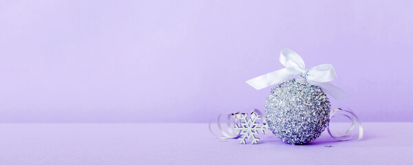 Christmas ball on colored background. decoration bauble with ribbon bow with copy space