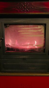 fuoco che arde nel braciere di una vecchia stufa in ghisa e creamica