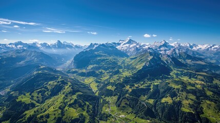 Obraz premium A stunning aerial view of the Swiss Alps in summer, with lush green valleys, snow-capped peaks, and clear blue skies