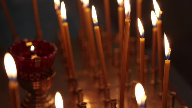 A lot of thick candles in the orthodox church temple near the altar.