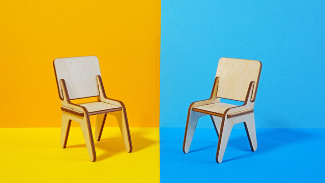 Negotiation Strategies, Job interview and Hiring Process. Difficult conversation concept. Two chairs stand opposite each other on blue and yellow background