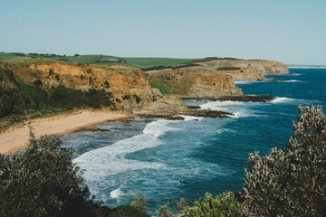Fototapeta premium Rugged Cliffs and Sandy Beach by the Ocean