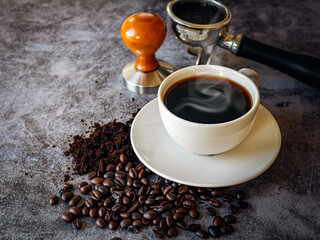 Coffee cup and beans with ground coffee on  gray background, Black coffee cup aromatic and making equipment, Tamper, Filter Basket