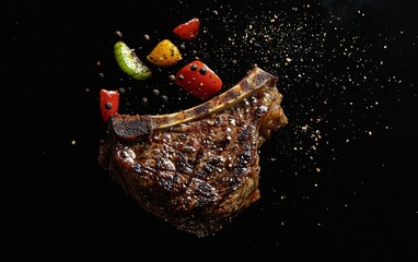 A grilled t-bone steak hovering mid-air with black pepper and charred vegetables, on a black background
