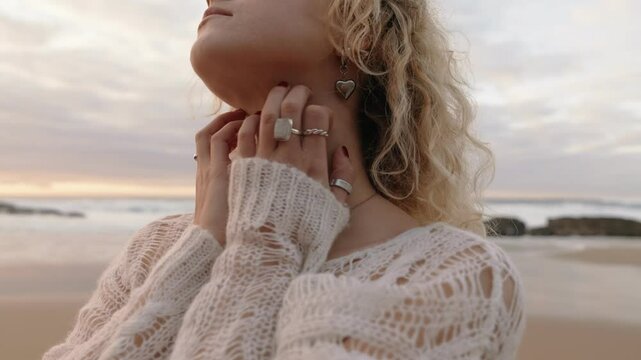 Close-up of a woman expressing abstract dance improvisation near the ocean at sunset, conveying passion and serenity.