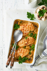 Baked chicken breast bbq with mushrooms and garlic in cream sauce on white wooden table backgrounds. Top view image with ingredients for cooking. Top view with copy space.