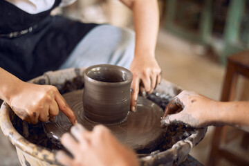Hands of craftsman artist working on pottery wheel.