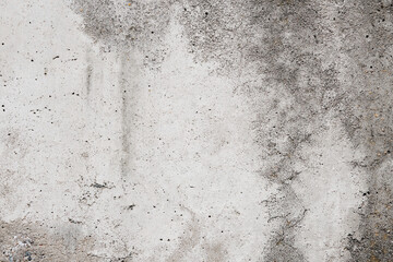 Cracked concrete wall covered with gray cement surface. Grey old wall with shabby damaged plaster or cement and brick background of an vintage dirty exfoliating plaster. Mock up.