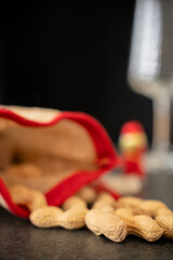 Christmas sack on a dark table. A wine glass and a foil wrapped chocolate Santa blurry in the background. Selective focus.