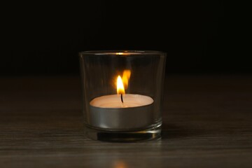 Burning candle in a dark space