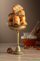 Baklava with walnuts and honey on a beige background.