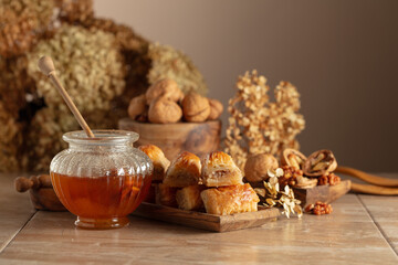 Baklava with walnuts and honey on a beige background.