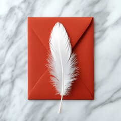 A white feather on a red envelope. Creative flat lay on light marble background.