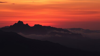 Dark mountain range silhouette with misty fog at sunrise, silhouette, remote, natural, sunrise