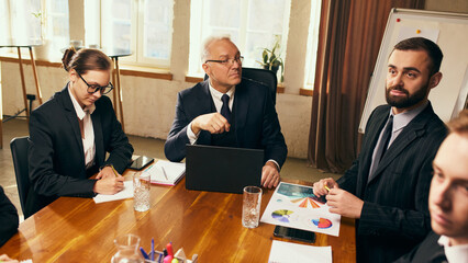 Group of employees attending meeting with their senior leader, discussing ideas, project strategies and analytics. Concept of business, teamwork, professional development