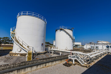 Crude Oil Industry, White Storage Fuel Gas Container Tanks in Petroleum Refinery Industrial Factory area against