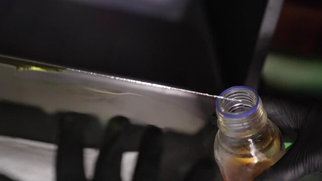 pouring back liquid Collodion from the wet glass plate with Rubber gloves for film photography
