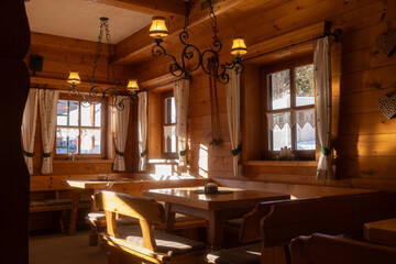 Cozy wooden interior of a mountain restaurant in the late afternoon light with rustic decor and tranquil ambiance