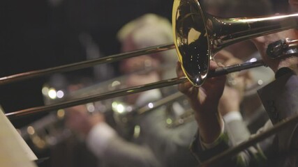 A trombonist playing their instrument in a brass band concert